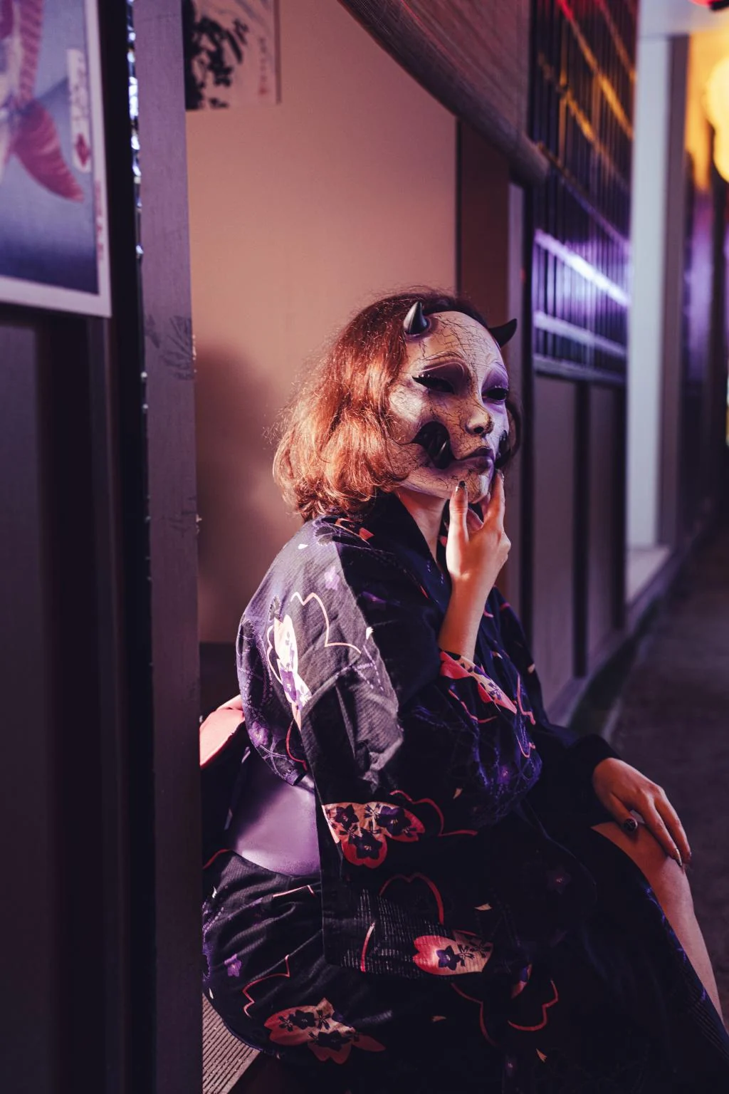 Máscara Kuchisake-Onna violeta craquelada llevada con kimono oscuro