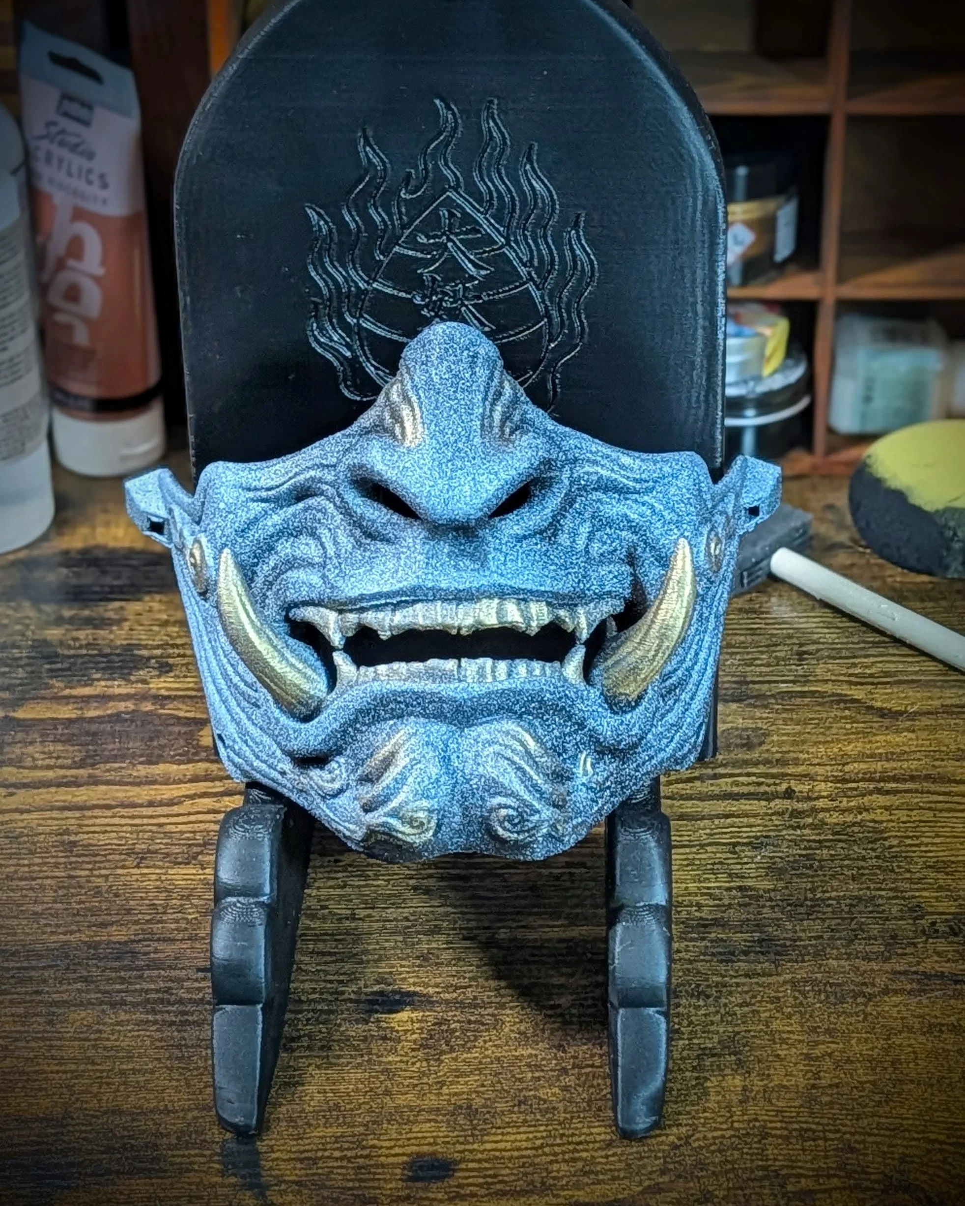 Demi-masque Mempo Oni bleu, tenu en main