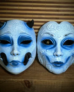 Masques Geisha et Kuchisake version Yuki-onna bleu vus de face, peinture craquelée blanche et bleue.