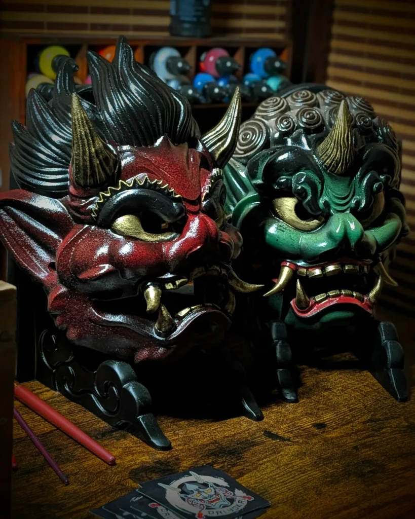 Duo de masques Raijin et Fujin faits main, inspirés des dieux japonais du tonnerre et du vent.