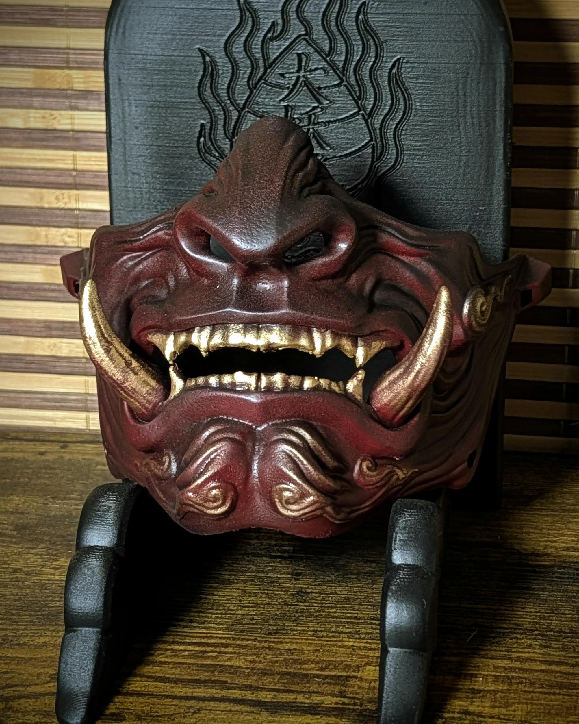 Demi-masque Mempo Oni rouge à dents dorées, vue de face