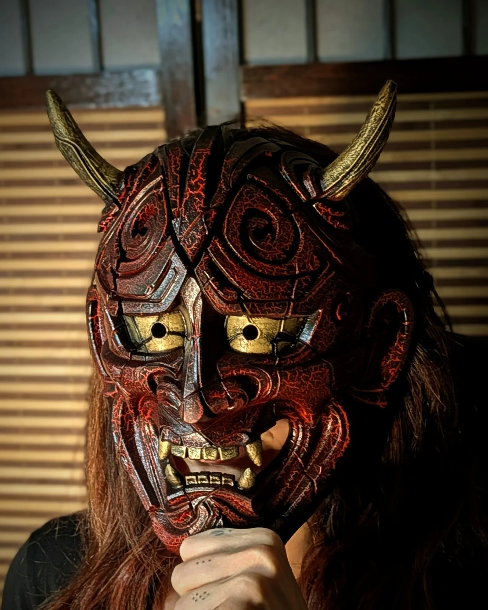 Máscara Hannya Kezurata roja llevada, con relieves craquelados y cuernos dorados