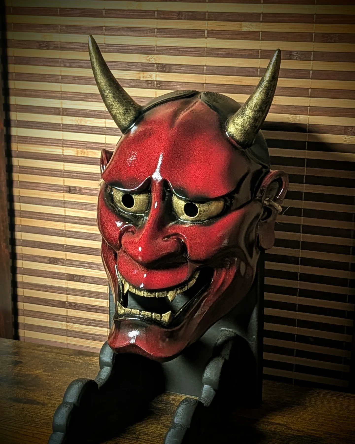 Masque Hannya rouge brillant vu de profil, cornes dorées et peinture à la main