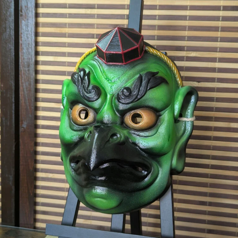 Green Karasu Tengu warrior mask on a display stand, three-quarter view