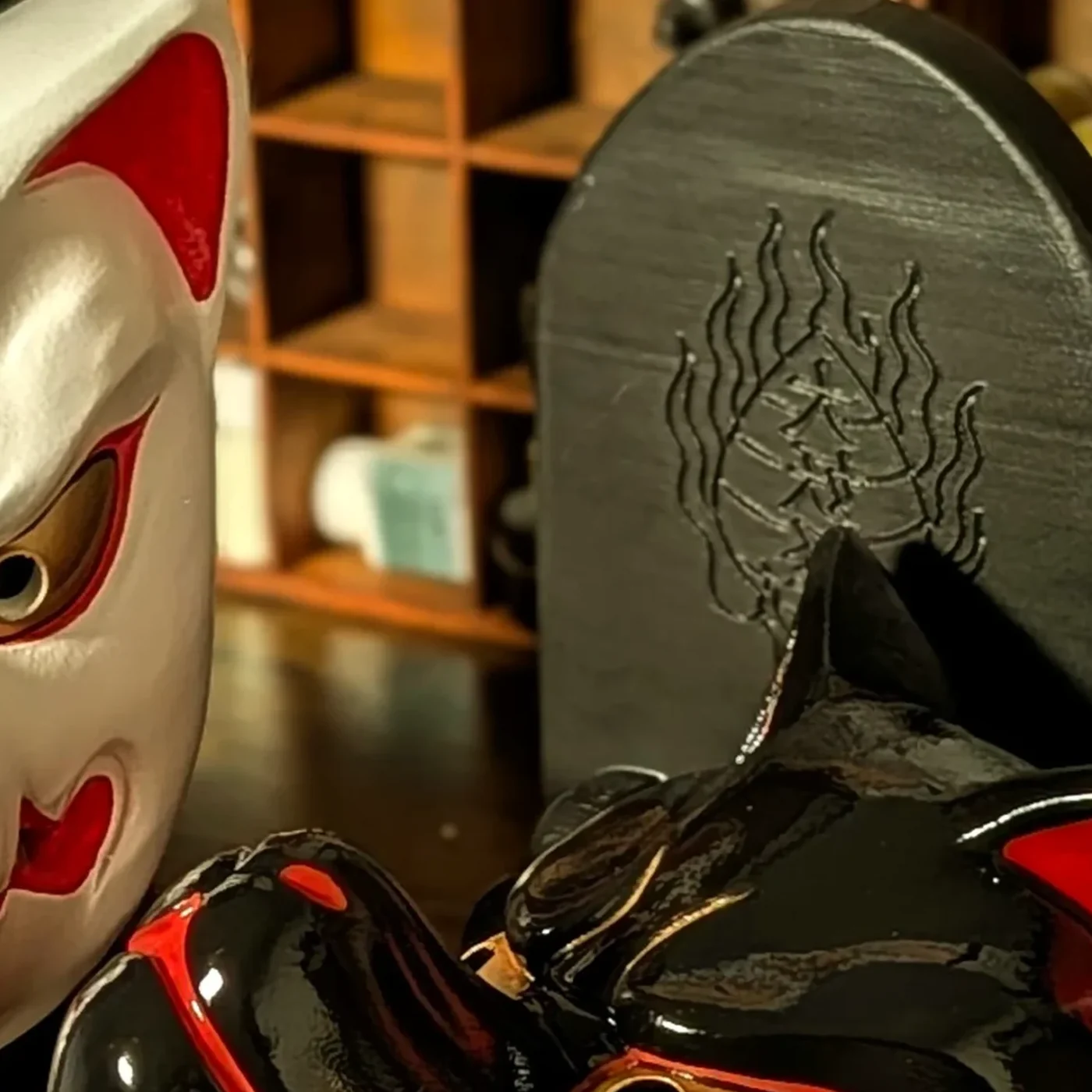 Masque Kitsune noir traditionnel présenté avec son socle noir, pièce artisanale Dai Yokai.