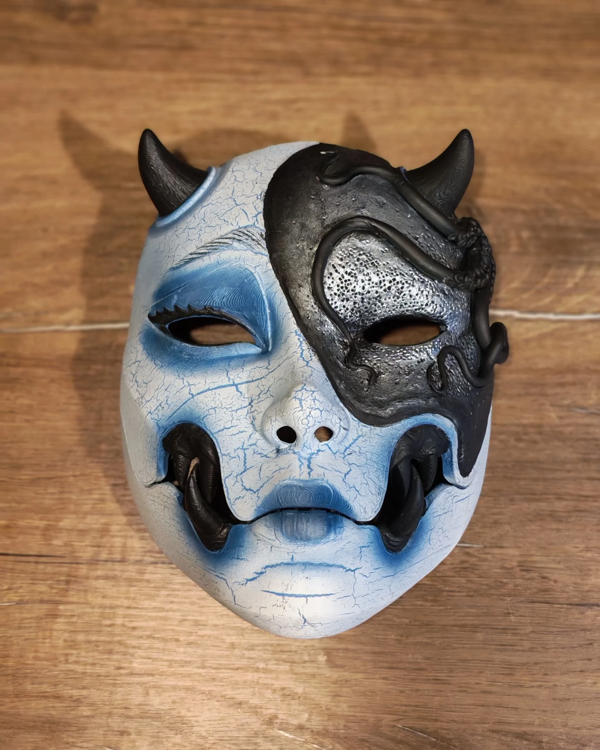 Masque Kuchisake x Adopte ton Poulpe bleu, vue frontale sur table, bouche articulée fermée.
