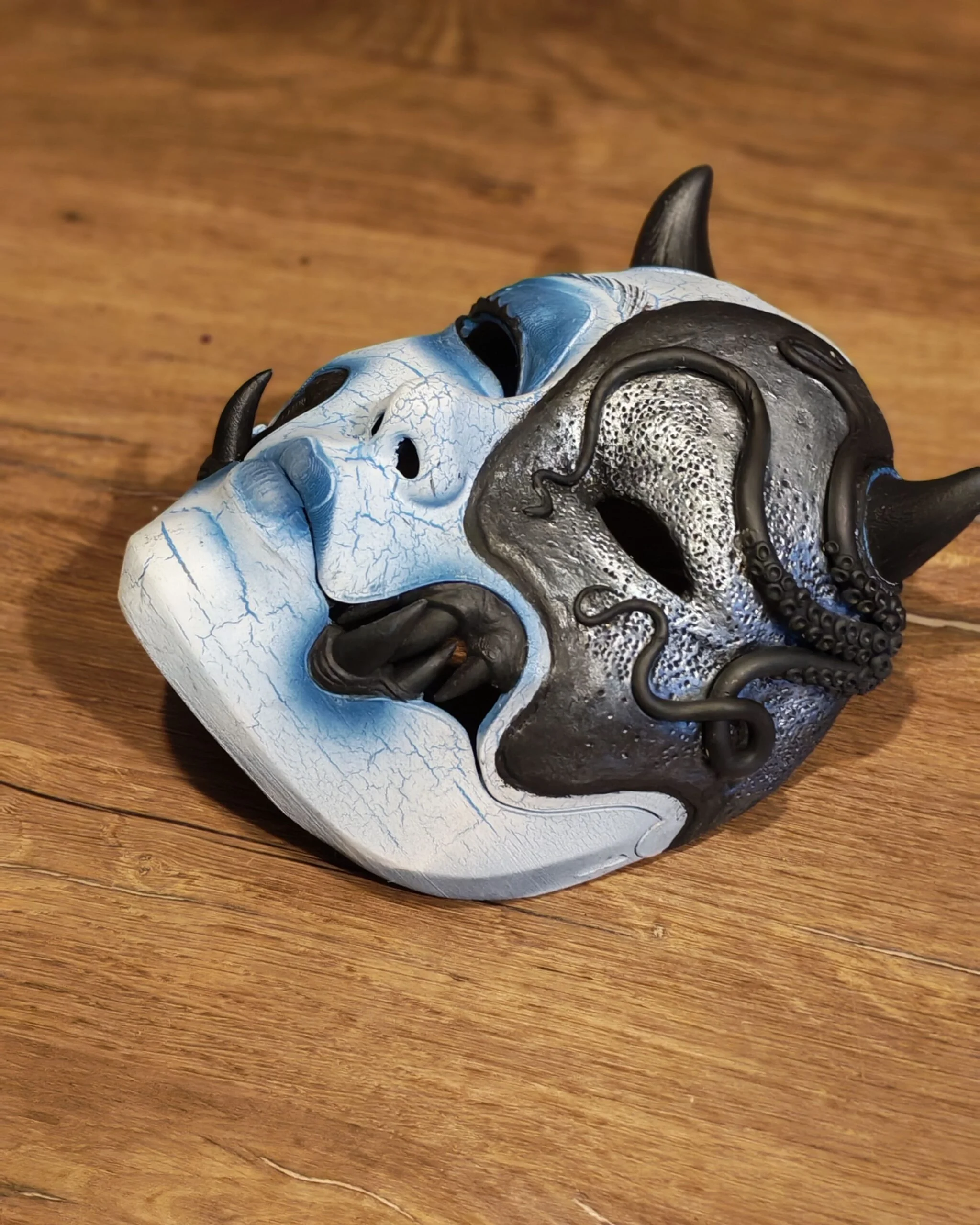Masque Kuchisake x Adopte ton Poulpe bleu, vue principale du masque articulé posé à plat.