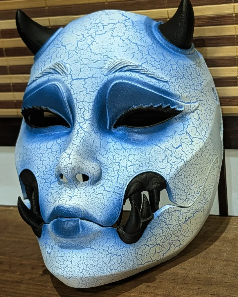 Masque Kuchisake version Yuki-onna bleu, vu de trois quarts, avec dents noires et effet glacé.