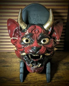 Masque Neko Hannya, chat démon - Masque Neko Hannya rouge, noir et or, vue de face sur son socle noir