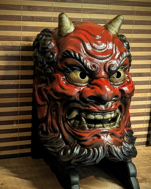 Masque Oni démon gardien japonais rouge vu de face sur son support
