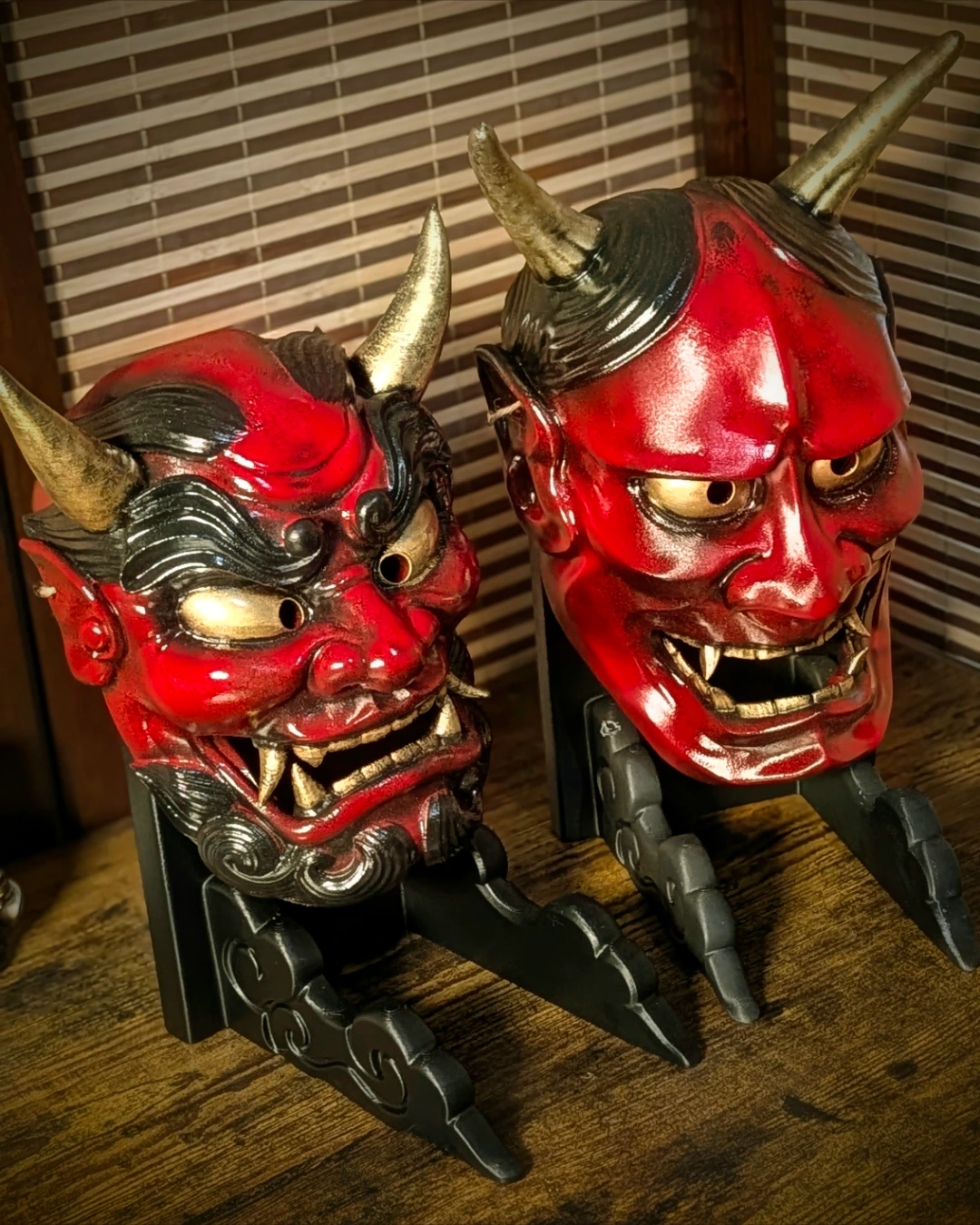 Maschera Oni rossa e maschera Hannya rossa su supporti, dipinte da Dai Yokai.