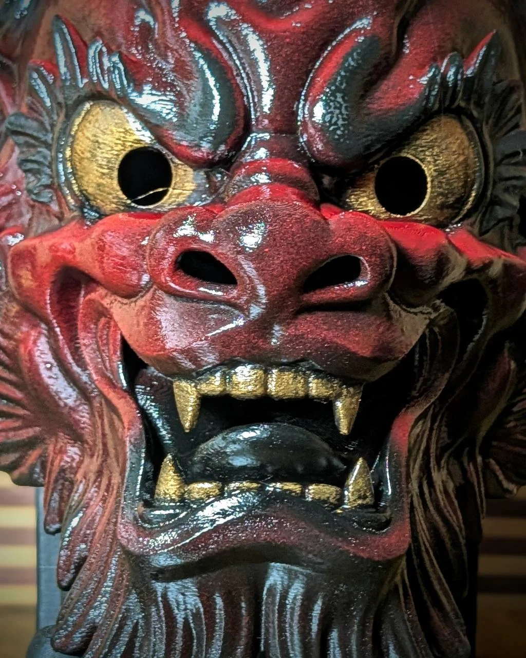 Masque Oni Irezumi bordeaux en gros plan, dents dorées et langue noire