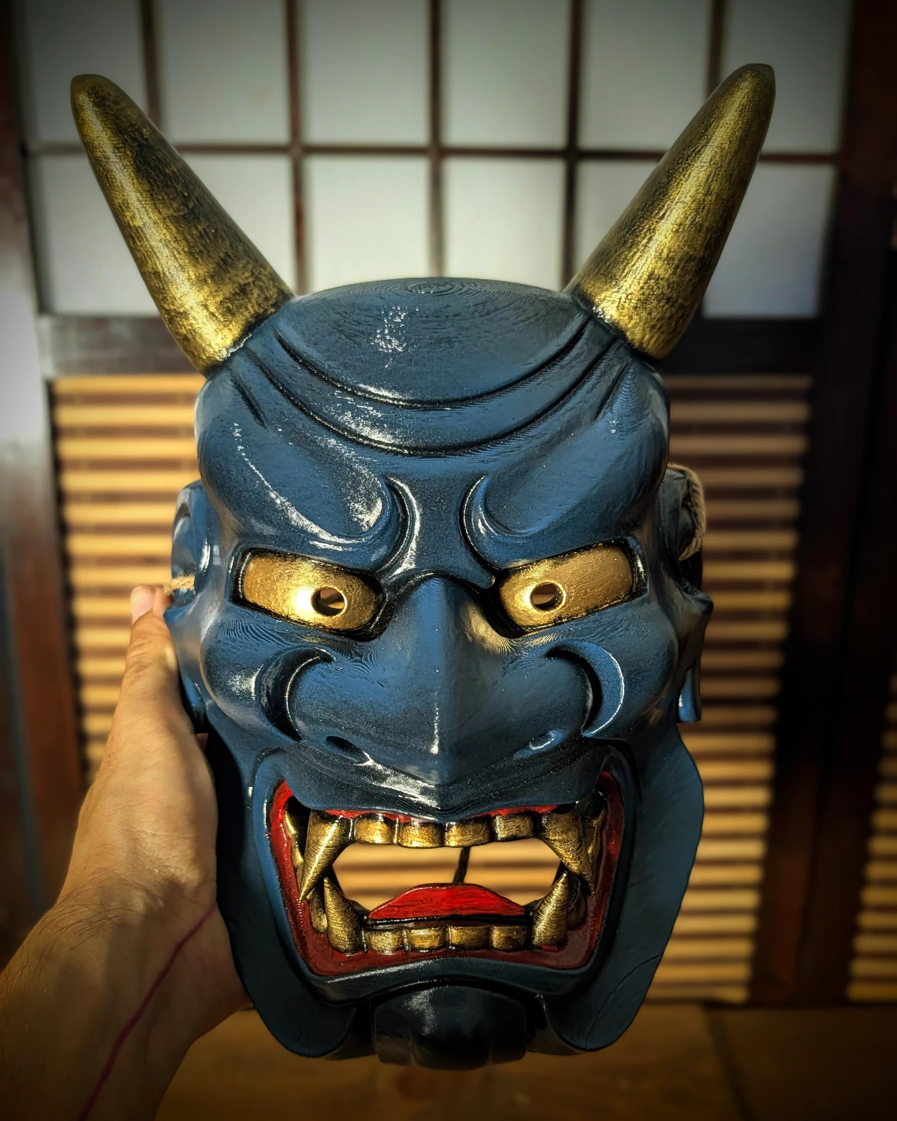 Masque Oni Ondeko bleu tenu en main, vue de face