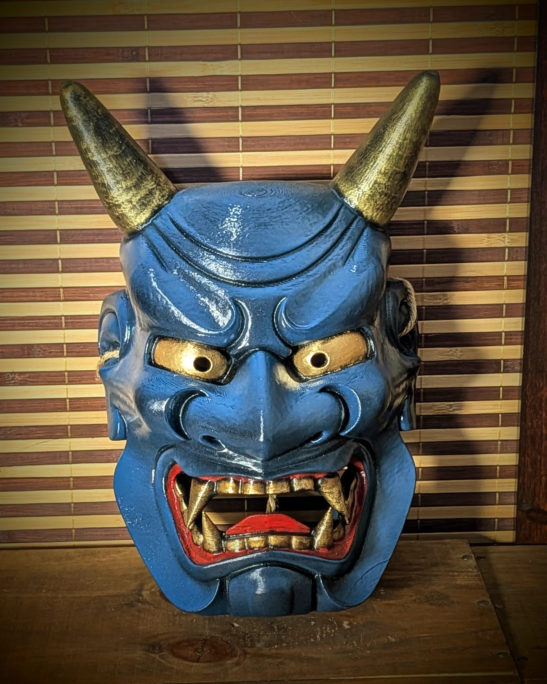 Masque Oni Ondeko bleu vu de face sur son support