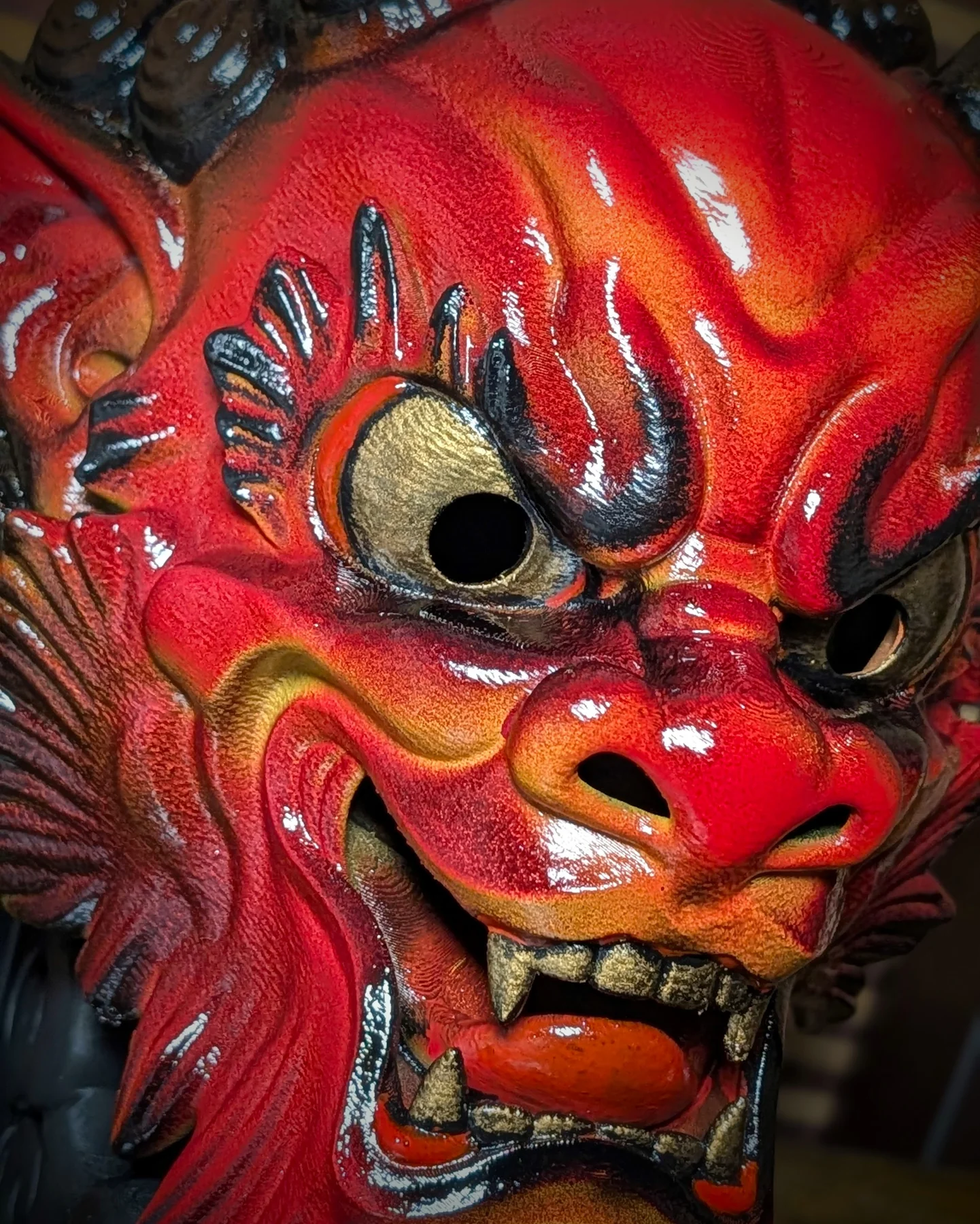 Gros plan sur le visage du masque Oni Irezumi rouge, dents et cornes dorées