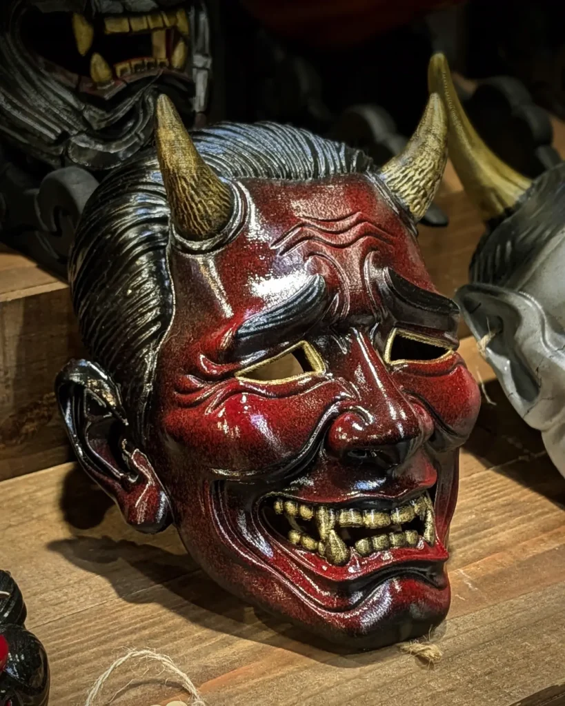 Red and gold Oni mask among pieces in the Dai Yokai workshop in Brittany