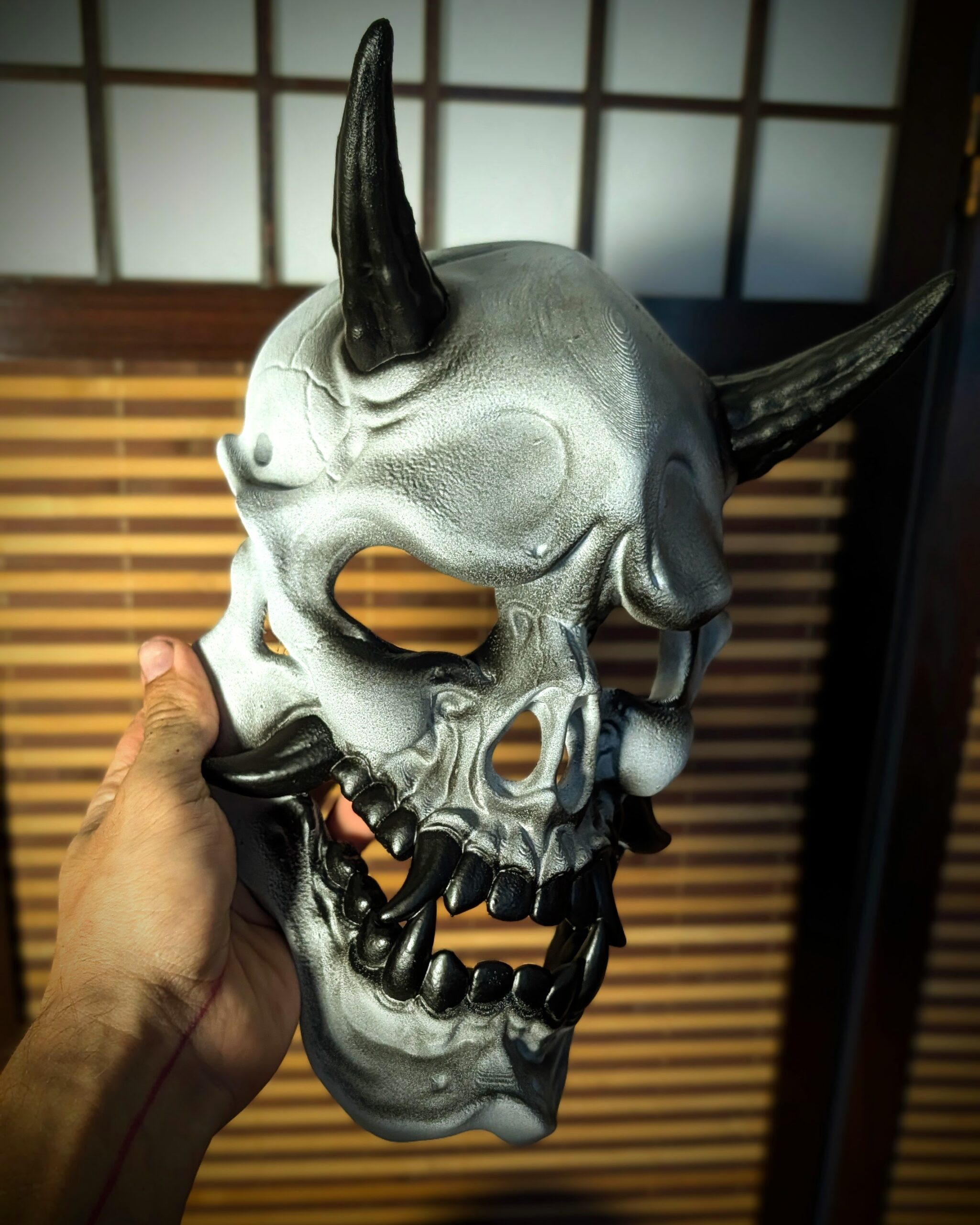 Masque Gashadokuro Hannya tenu en main pour montrer sa taille