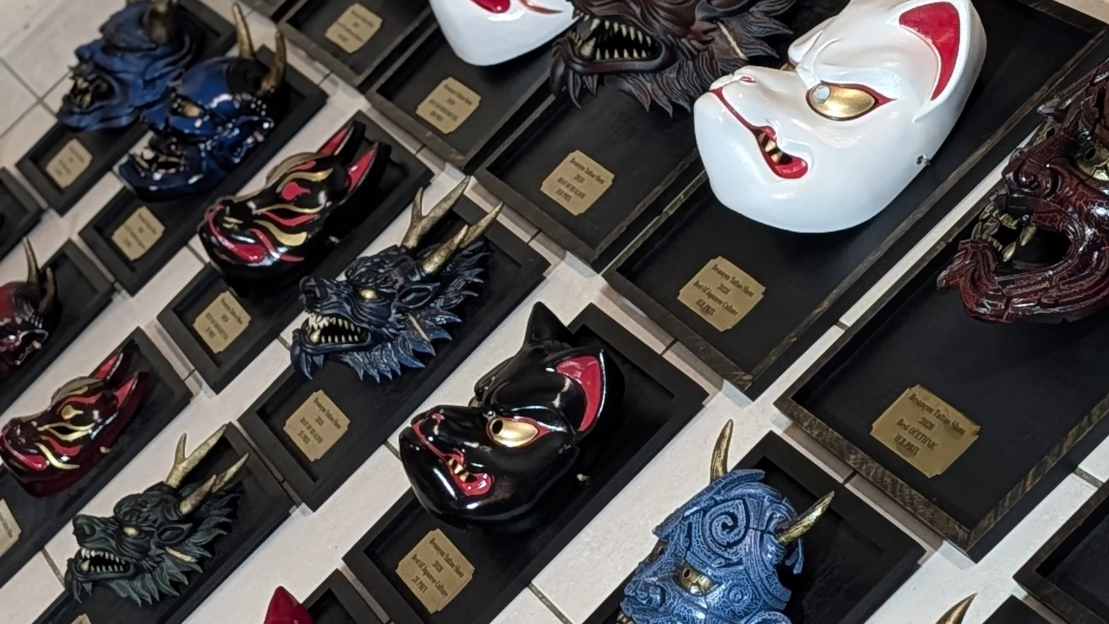 Detail of Dai Yokai BITS 2026 trophy masks on their black frames