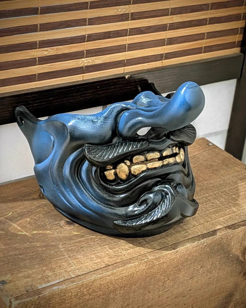 Demi-masque Tengu Kaze bleu et noir avec dents dorées, vue trois-quarts