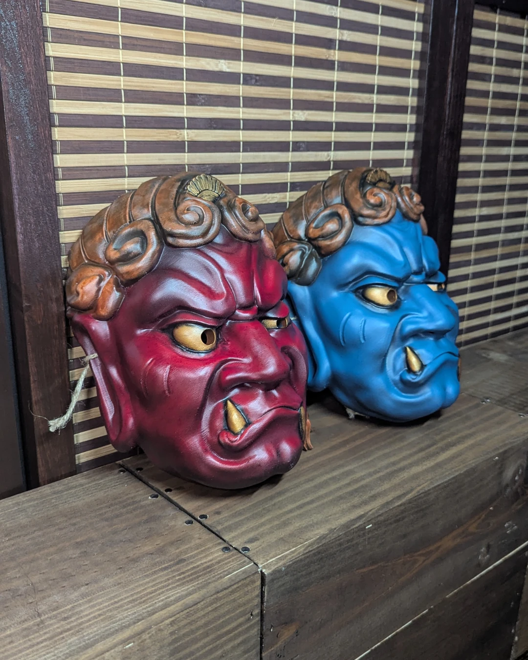 Duo de masques Fudō Myō-ō rouge et bleu, vue de trois-quarts côte à côte