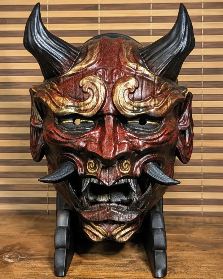 Masque Hannya personnalisé rouge, brun et or sur un support Dai Yokai
