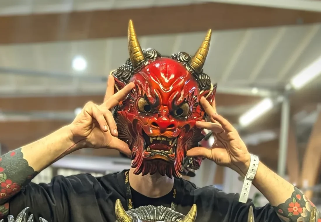 Oni Irezumi rouge feu tenu devant le visage, cornes dorées et mains de chaque côté