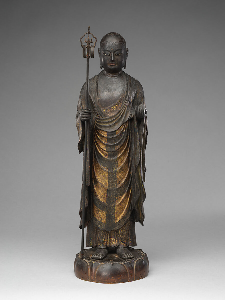 Estatua histórica de Jizō de pie, con hábito de monje y bastón, sobre una base de loto.