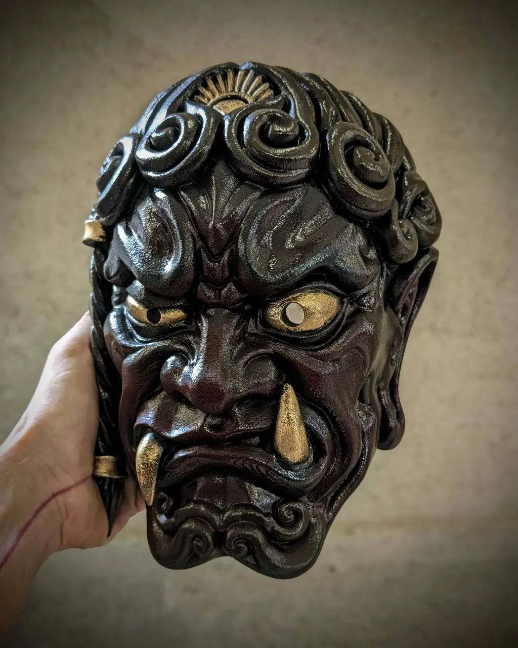 Máscara Fudō Myōō, trenza a la derecha, rojo, vista frontal, sostenida en la mano.