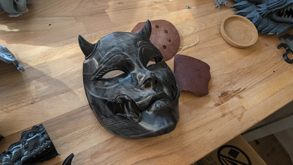 Sanded Kuchisake Onna mask on the workbench with abrasives, before painting